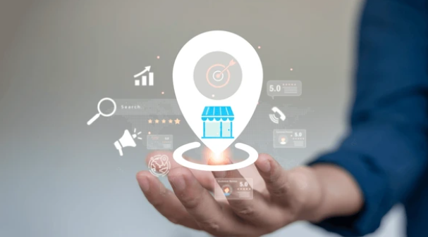 Hand presenting a digital location pin with business and SEO icons, symbolizing local search optimization for small businesses.