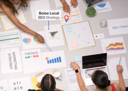 Overhead view of a diverse marketing team collaborating at a meeting table filled with charts, graphs, and strategy documents. A location pin and label read “Boise Local SEO Strategy,” emphasizing the team’s focus on regional digital marketing planning.