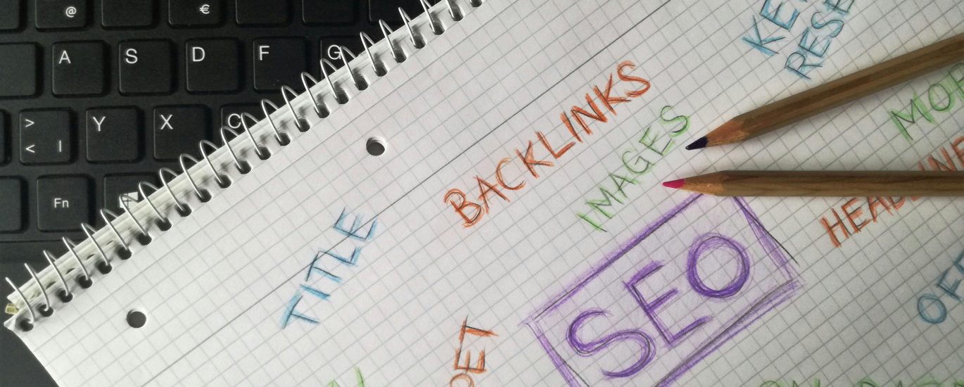 Notebook with SEO terms including backlinks, keyword research, and social media next to keyboard — representing Boise SEO strategy