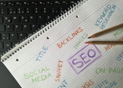 Notebook with SEO terms including backlinks, keyword research, and social media next to keyboard — representing Boise SEO strategy